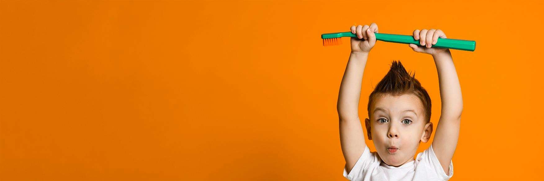 Boy holding a tooth brush in Royal Oak, MI
