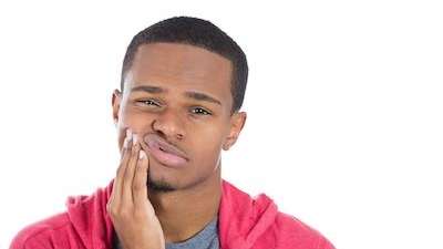 Patient holding his jaws due to tooth pains