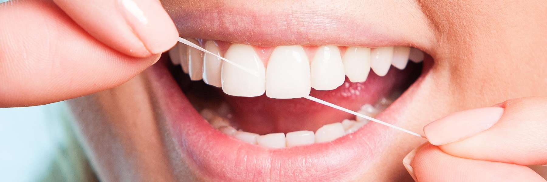 A patient flossing her teeth in Royal Oak