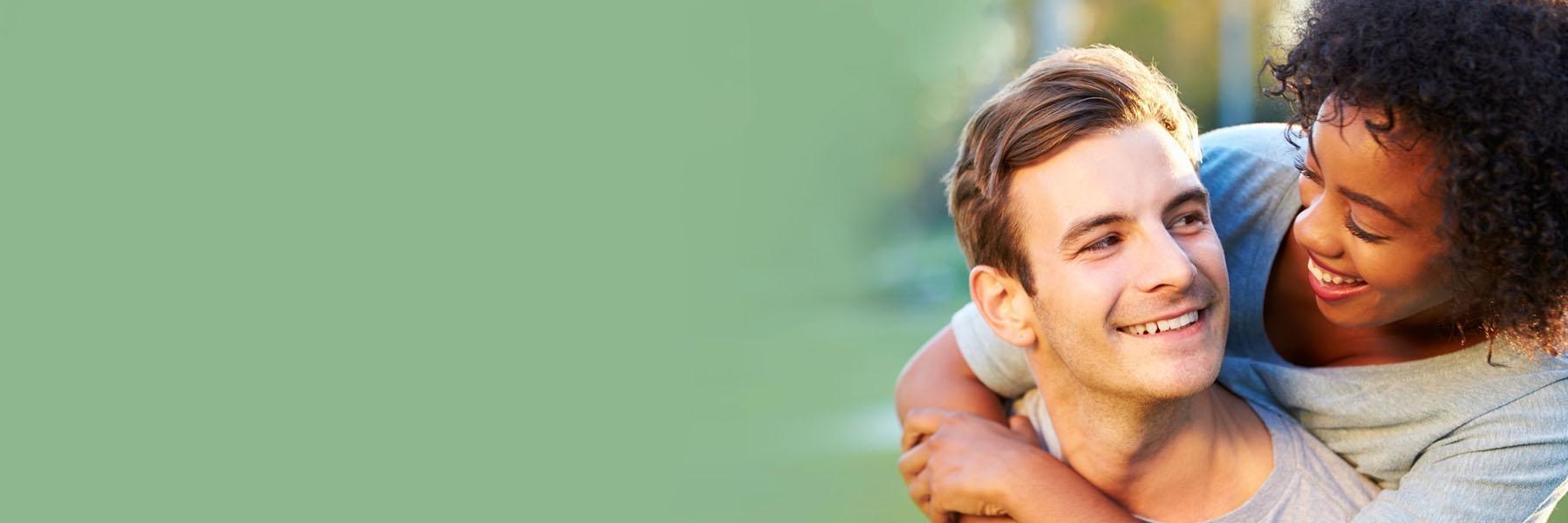 Young couple hugging & smiling l Dentist Ferndale MI